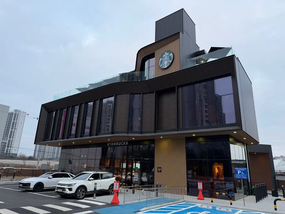 건물 상부 타워에 사이렌 로고 사인을 단 드라이브스루 매장