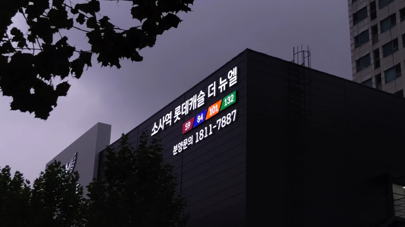 단지명·평형 색 블록·분양문의 번호를 입체 문자로 단 견본주택 외벽